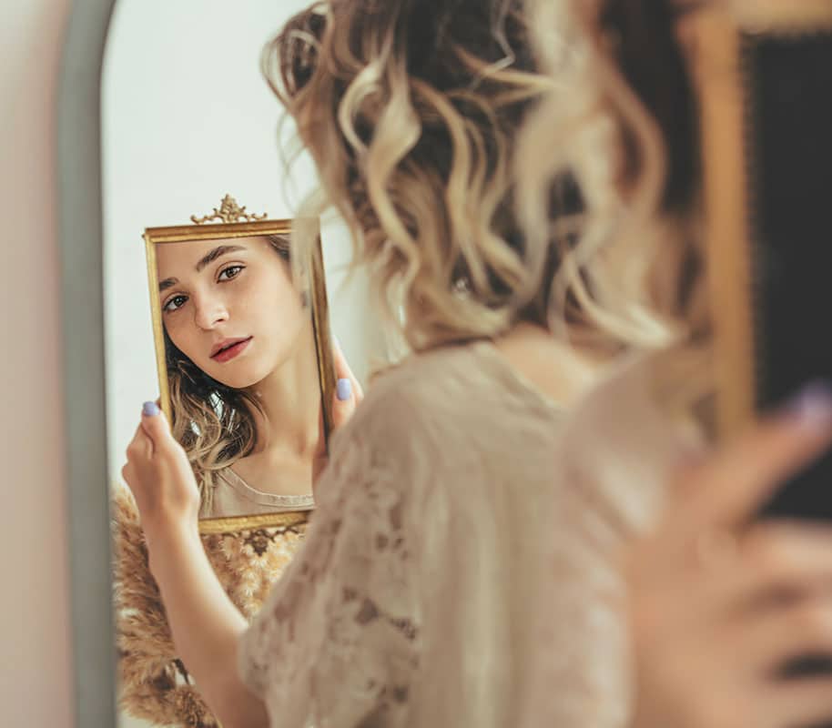 a woman looking at the mirror
